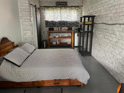 - une chambre avec un lit et un mur en briques blanches dans l'établissement Blissful Stay, à Potchefstroom