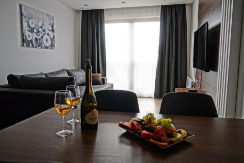 un tavolo con due bicchieri di vino e un cesto di frutta di Apart & Spa Zoned a Kopaonik
