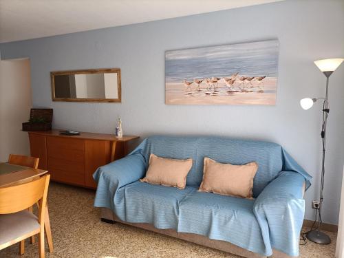 a living room with a blue couch and a table at Apartamento Laurel in Peñíscola