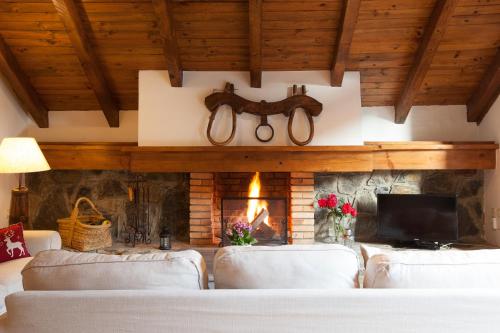 a living room with two couches and a fireplace at Tarter Chalets Apartaments in El Tarter