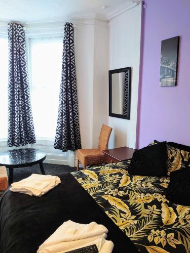 um quarto com uma cama, uma mesa e uma janela em Bloomfield Hotel em Blackpool