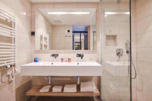 a bathroom with a white sink and a mirror at Hotel Park Plava Laguna in Poreč