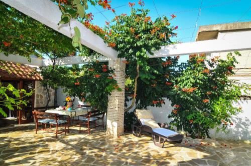 patio z dwoma drzewami, stołem i krzesłami w obiekcie Apartments Villa Stankovic w mieście Tivat