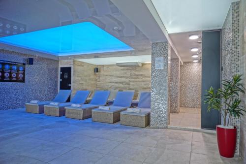 a waiting room with blue chairs and a blue ceiling at Apart & Spa Zoned in Kopaonik