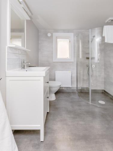 a white bathroom with a shower and a toilet at Isaberg Golfklubb in Hestra