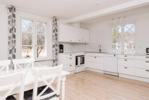 a kitchen with white cabinets and a table and chairs at Isaberg Golfklubb in Hestra