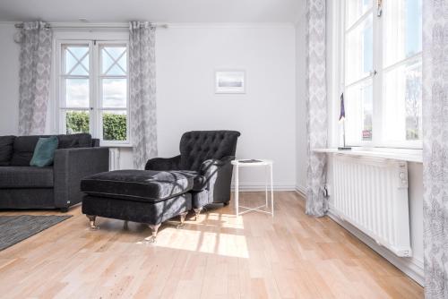 a living room with a black chair and a couch at Isaberg Golfklubb in Hestra