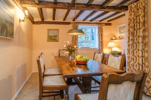 Gunhill Cottages - Aldeburgh Coastal Cottages في Levington: غرفة طعام مع طاولة وكراسي خشبية