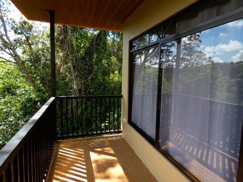 a balcony with a view of the trees at Tapiru's House - Bahia Drake in Drake
