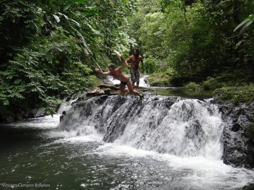 two men standing on top of a waterfall at Tapiru's House - Bahia Drake in Drake