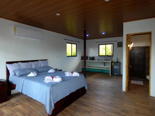 a bedroom with a bed with towels on it at Tapiru's House - Bahia Drake in Drake