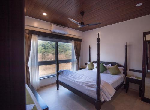 a bedroom with a bed and a large window at Mastiff Grand La Villae in Lonavala