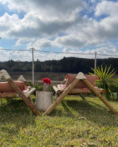 two chairs sitting in the grass next to a fence at El Lagar de los Abuelos in Arcos de la Frontera