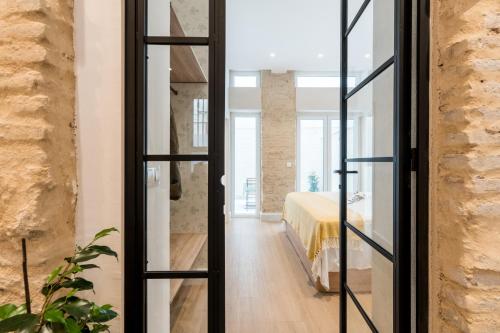 um quarto com uma cama e portas de vidro em BeHouse Arroyo A em Sevilha
