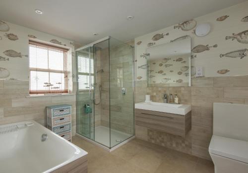 y baño con bañera, lavamanos y ducha. en The Beach House en North Berwick