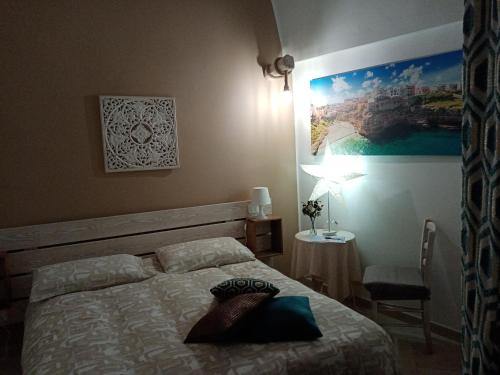 1 dormitorio con 1 cama y 1 mesa con lámpara en Le Ninfe del Mare en Polignano a Mare