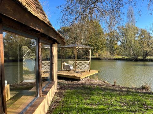 une maison avec un quai sur l'eau dans l'établissement La maison de l'O, à Saint-Laurent-des-Hommes
