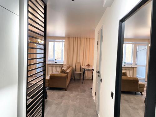 Una sala de estar con un sofá y una silla en una habitación. en Lux apartment on Astana 12/1, en Öskemen