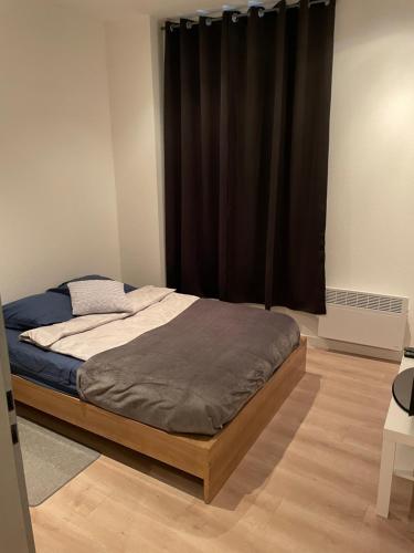 1 cama en un dormitorio con cortina negra en Chaleureux F2 dans l’hypercentre colmarien en Colmar