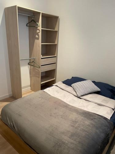 - une chambre avec un lit et une étagère dans l'établissement Chaleureux F2 dans l’hypercentre colmarien, à Colmar