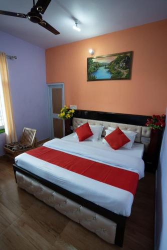a bedroom with a large bed with red and white pillows at Riva palace Homestay Rewalsar Lake in Malther