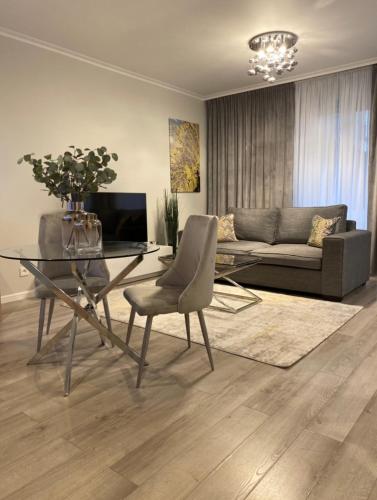 a living room with a glass table and a couch at Ultra Apartments Kamienica Nova in Szczecin