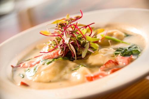 a white bowl of food with a salad on top at Pleasant View Inn in Westerly