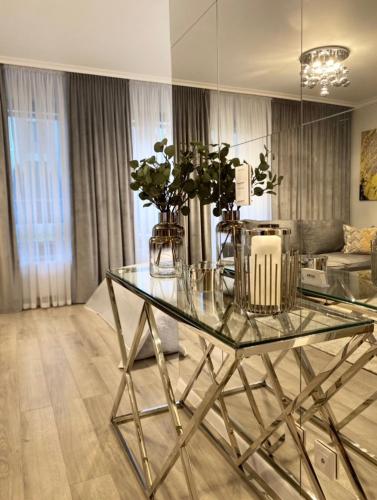 a glass table with flowers in a living room at Ultra Apartments Kamienica Nova in Szczecin