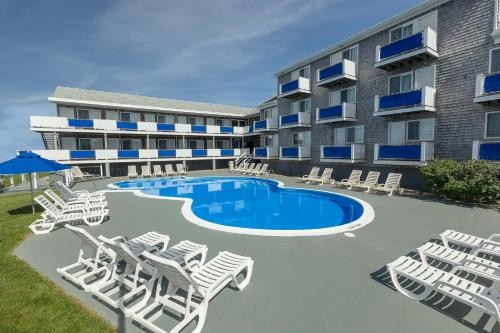 a resort with a pool and lounge chairs and a building at Pleasant View Inn in Westerly