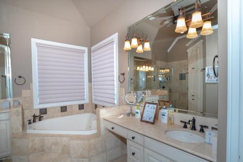 a bathroom with a tub and a sink and a bath tub at Luxury 5 Acre Private Estate on Lake Ray Roberts in Sanger