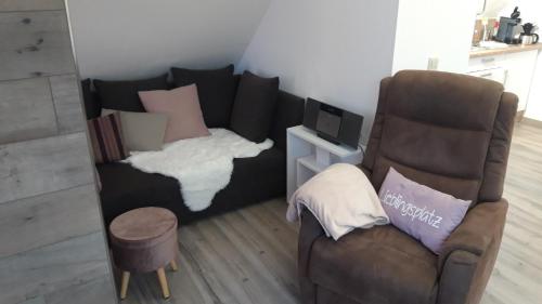 a living room with a couch and a chair at Ferienwohnung an der Kurklinik in Bad Driburg
