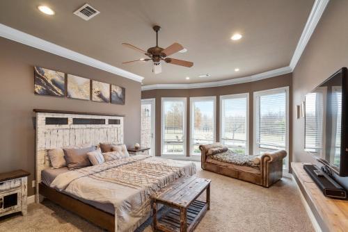 a bedroom with a bed and a tv and windows at Luxury 5 Acre Private Estate on Lake Ray Roberts in Sanger