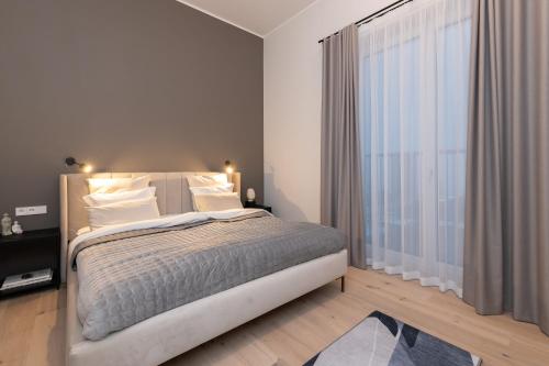 Un dormitorio con una cama y una ventana grande. en DasHaus 2 bedroom Apartment, en Tallin