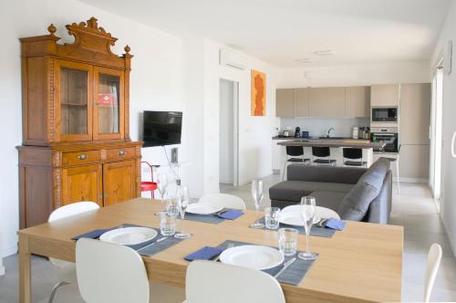 a dining room and living room with a table and chairs at BnButler - Govone - Ampio e Luminoso Appartamento con Terrazza in Milan