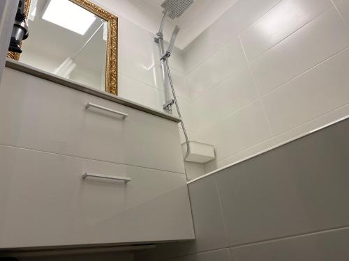 a bathroom with white walls and a mirror and stairs at TY LAUMANN sur le PORT petite maison avec jardin - Parking gratuit in Vannes