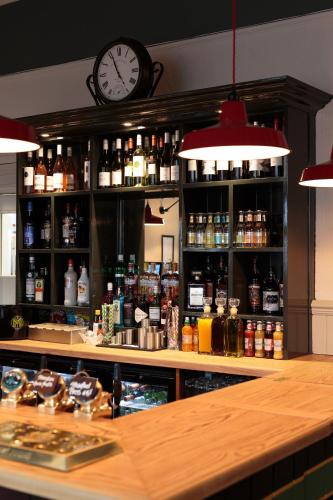a bar with a clock on the wall behind it at The Crabtree Inn in Shoreham-by-Sea
