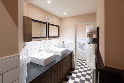 uma casa de banho com 2 lavatórios e um piso em xadrez em The Crabtree Inn em Shoreham-by-Sea