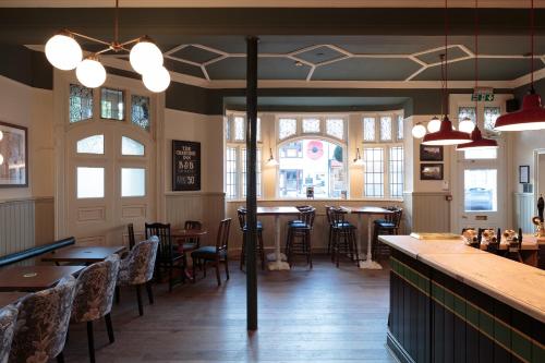 a restaurant with tables and chairs and a bar at The Crabtree Inn in Shoreham-by-Sea