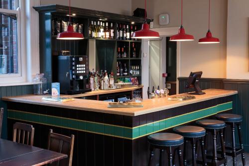 a bar in a restaurant with bar stools at The Crabtree Inn in Shoreham-by-Sea
