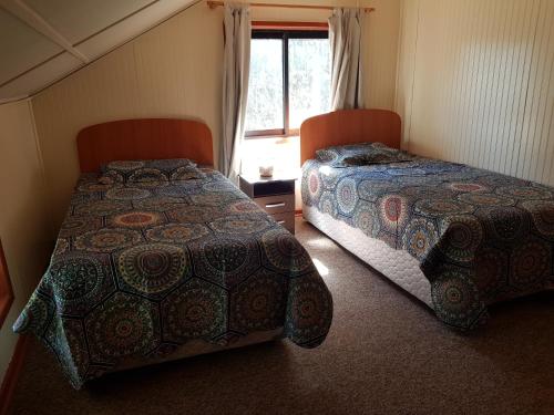 a bedroom with two beds and a window at Ema B and B in Río Bueno