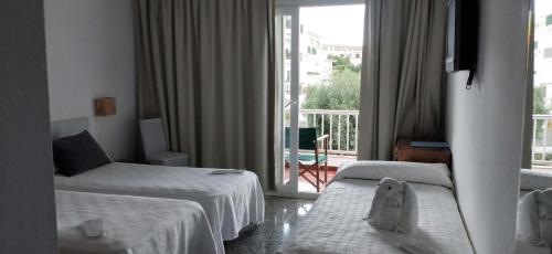 Postel nebo postele na pokoji v ubytování Hostal S'Algaret