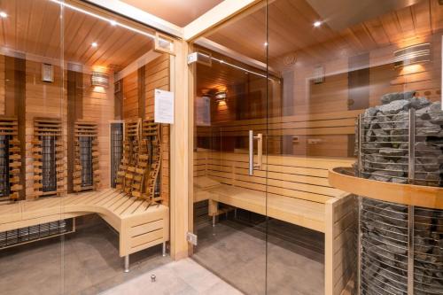 uma sauna com armários de madeira e uma parede de vidro em Apartamenty 4 i 45 w Willi Józefina em Szklarska Poręba