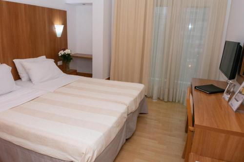 a hotel room with a bed and a television at Leto Boutique Hotel Agrinio in Agrinion