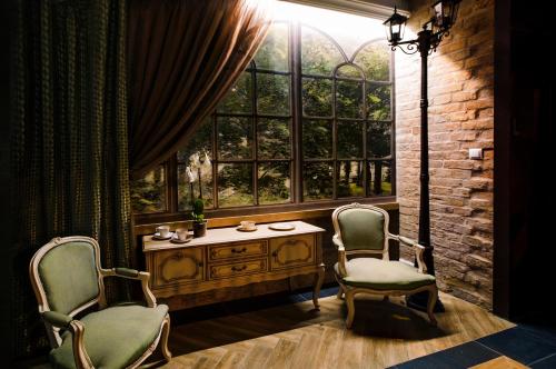 two chairs and a table in a room with a window at Kamienica Boutique ApartHotel in Białystok