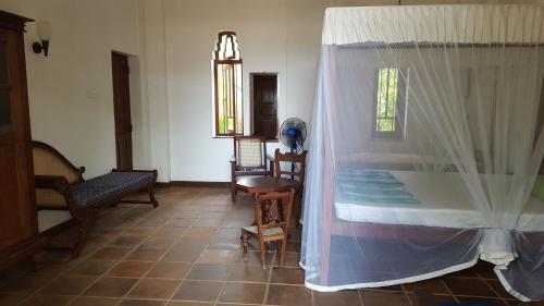 a room with a bed and a table and chairs at Villa Sunrise Ferienhaus in Tangalle