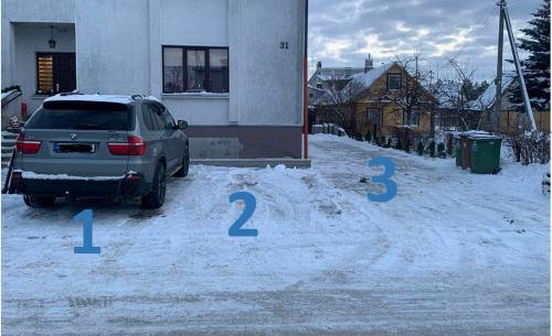a car parked in a parking lot in the snow at Sauliaus apartamentai VIP in Panevėžys