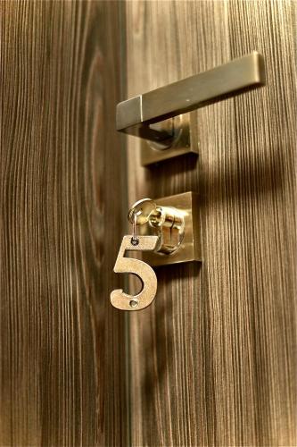 a number five hanging on a wooden door at Bacchus Pub és Panzió in Dunaharaszti