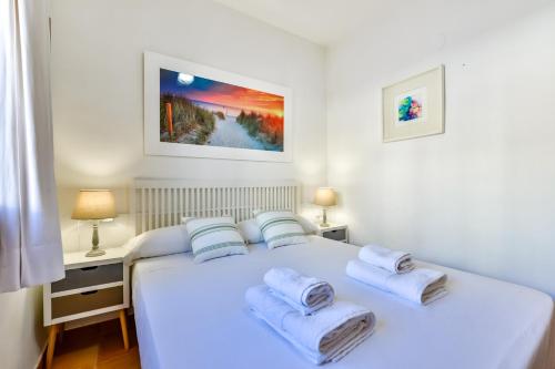 Un dormitorio con una cama blanca con toallas. en AITANA - Managed by Almarina, en Calpe
