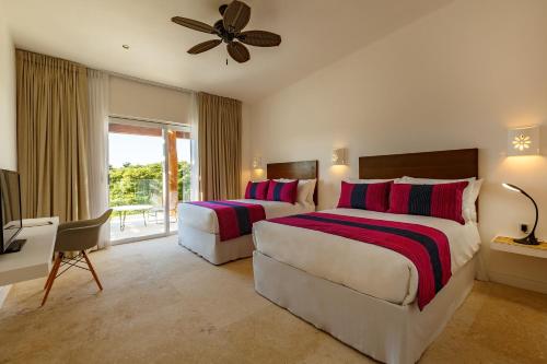 a hotel room with two beds and a television at HM Playa del Carmen in Playa del Carmen