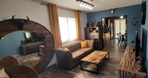 ル・ブールーにあるSuperbe appartement classé 4étoiles avec piscine privéeのソファと鏡のあるリビングルーム